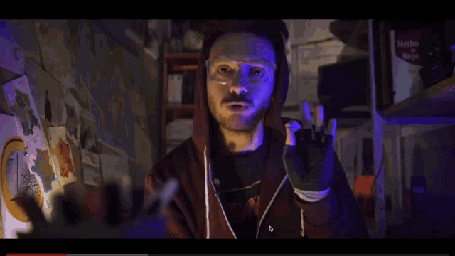 a man wearing glasses and a hoodie with the word iron on his shirt