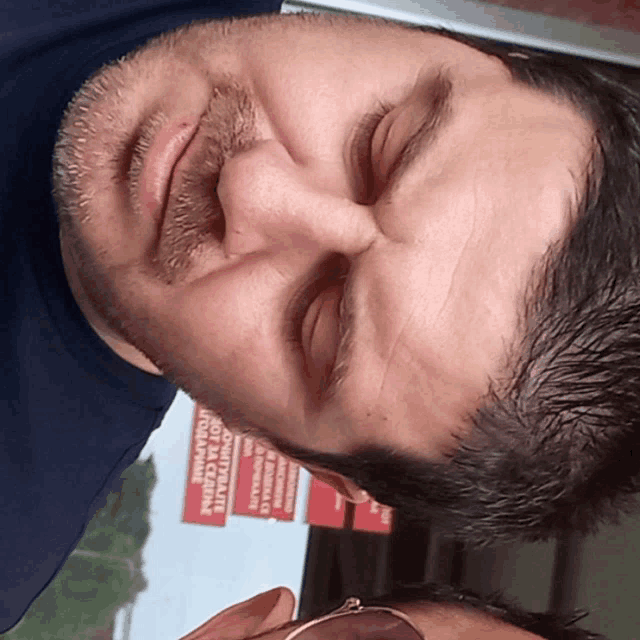 a man 's face is shown with a red sign in the background that says " no animals "