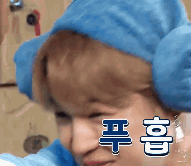 a close up of a person wearing a blue hat with chinese characters on it