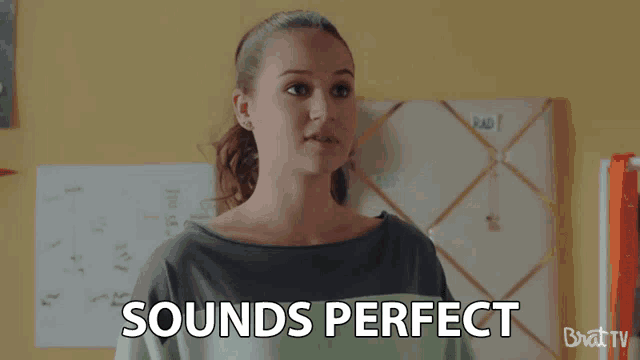 a woman stands in front of a board that says " sounds perfect "