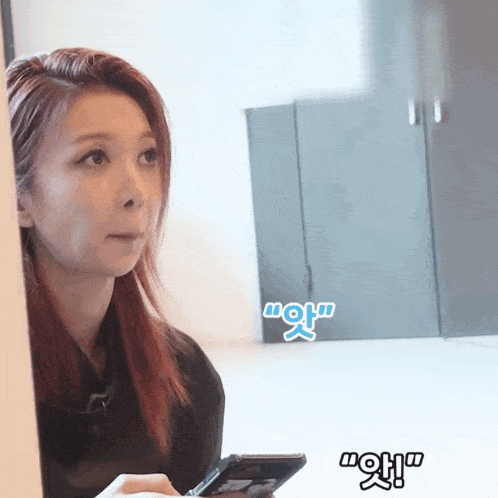 a woman with red hair is holding a cell phone with a sticker that says wow on it