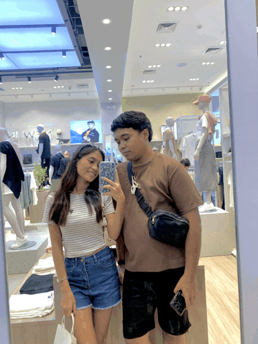 a woman taking a picture of herself and a man in a store