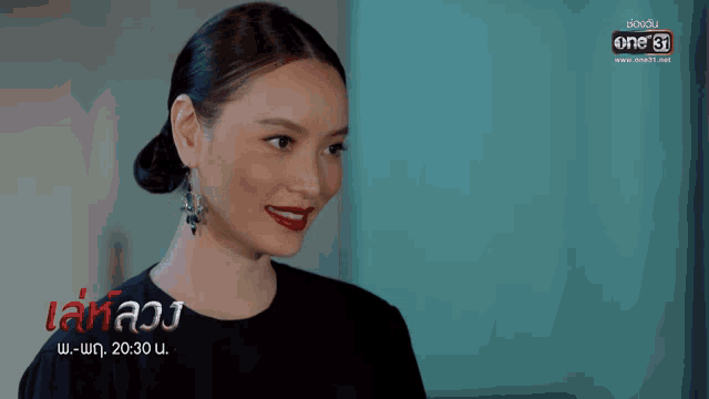 a woman wearing red lipstick and earrings is on a screen that says ' one 31 ' on it