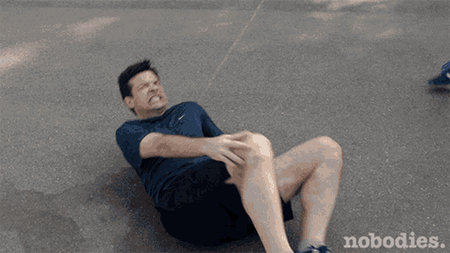 a man in a nike shirt is laying on the ground