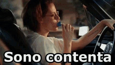 a woman is drinking from a bottle while driving a car and the word sono contenta is on the bottom of the image