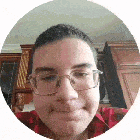 a young man wearing glasses and a plaid shirt is making a funny face .
