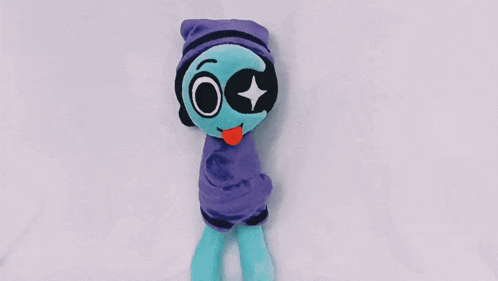 a stuffed alien wearing a purple beanie with a star in its eye