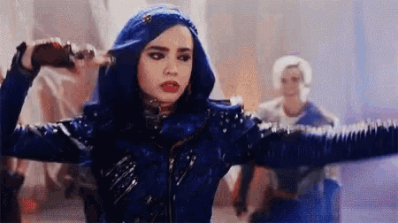 a woman with blue hair and a blue jacket is holding a bottle in her hand .