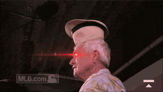 a man wearing a hat with red eyes and a mlb.com logo