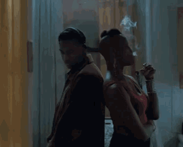a man and a woman are standing next to each other in a room .