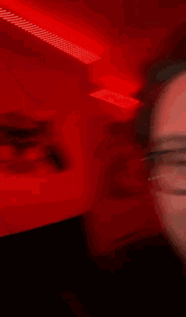 a man wearing glasses is making a peace sign with his finger