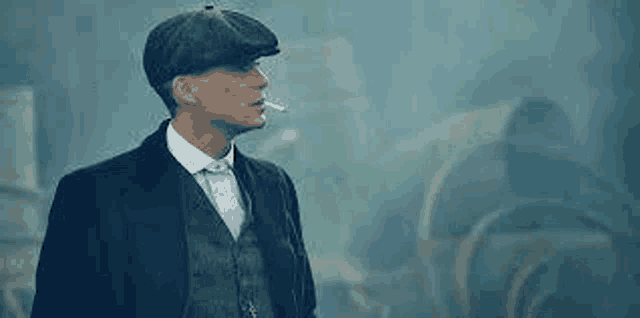a man in a suit and hat is smoking a cigarette in the fog .