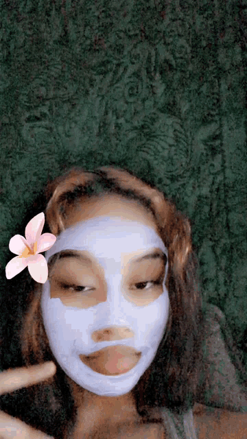 a girl wearing a purple face mask with a pink flower on her head