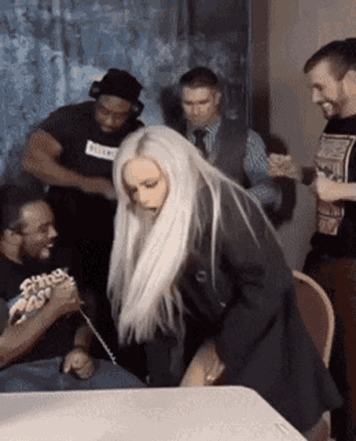 a group of people are gathered around a table with one man wearing a black shirt that says ' killer ' on it