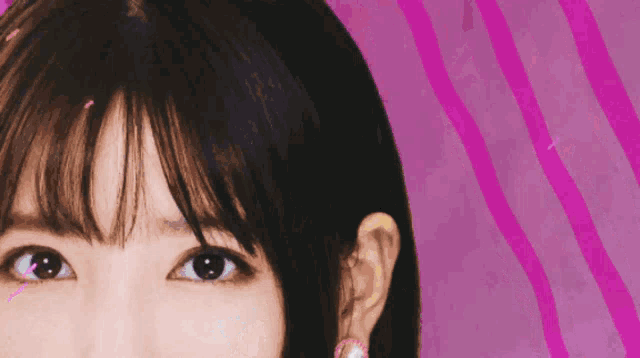 a close up of a woman 's face against a pink background