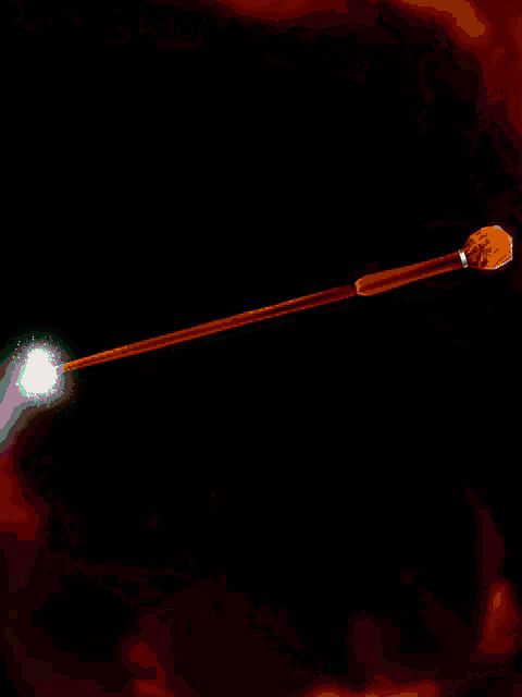 a gold wand with a green emerald on it is glowing in the dark