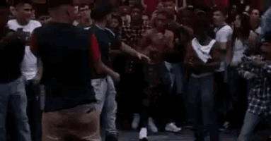a large group of people are standing in a crowd and dancing .