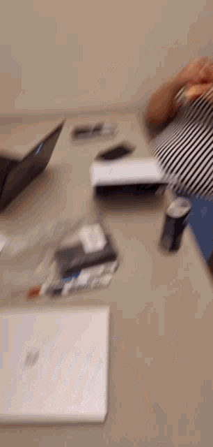 a blurry picture of a woman sitting at a desk with a can of soda