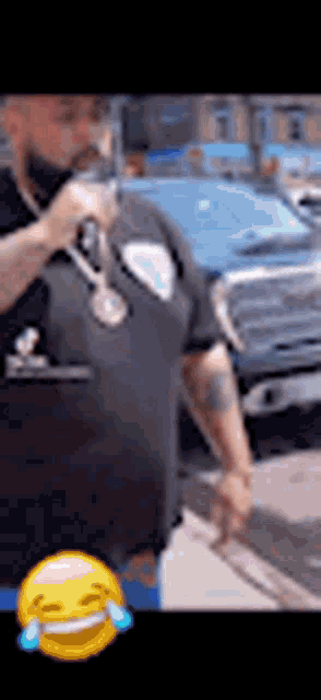 a man in a police uniform is holding a microphone in front of a blue car .