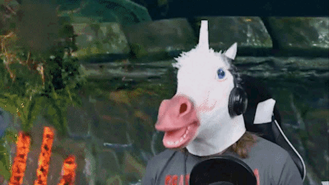 a man is wearing a unicorn mask and headphones