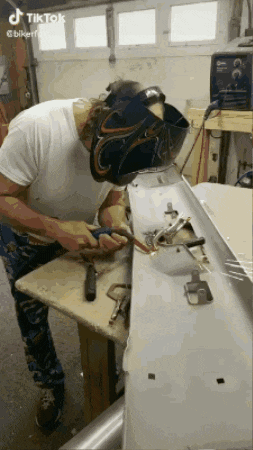 a man wearing a welding mask is working on a piece of metal