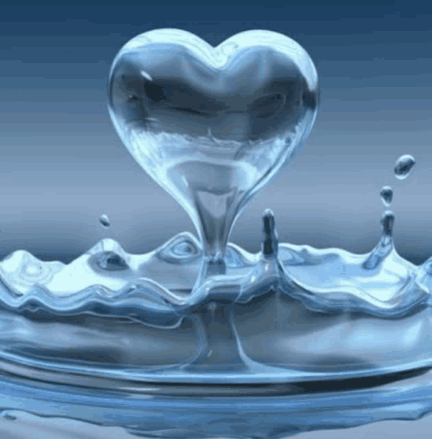 a heart shaped drop of water is being poured into a pool of water