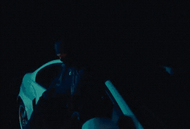 a man is standing next to a car in the dark