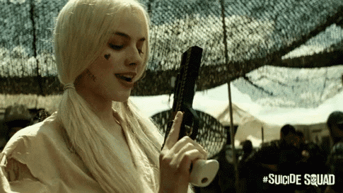a woman in a suicide squad costume is holding a gun in her hand