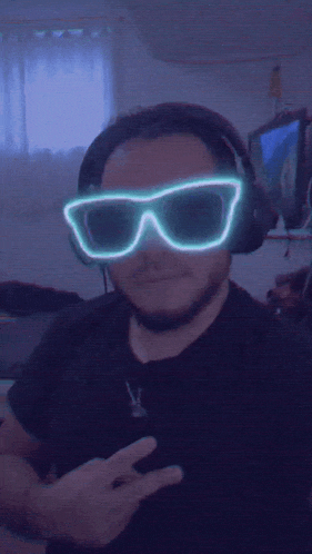 a man wearing headphones and neon sunglasses is giving a peace sign