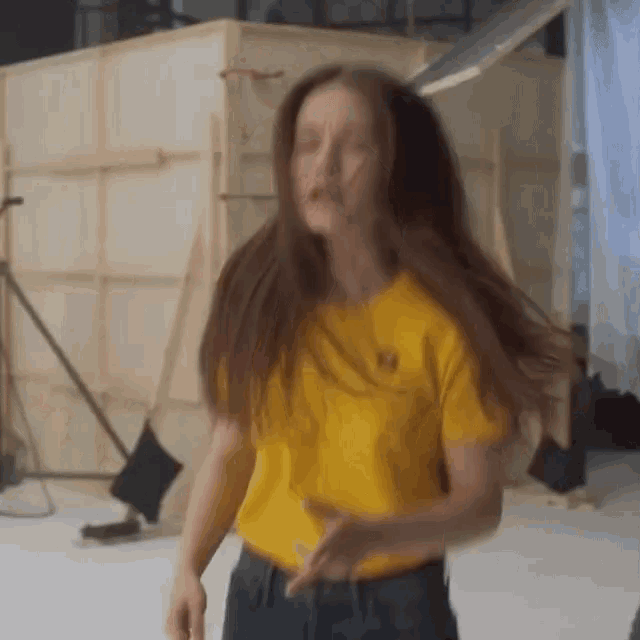 a woman wearing a yellow t-shirt with a smiley face embroidered on it
