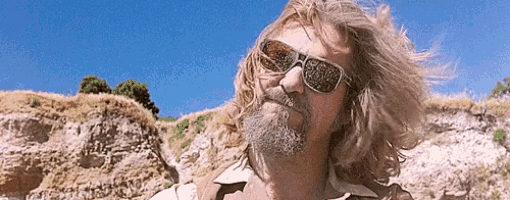 a man with long hair and a beard wearing sunglasses and a white shirt