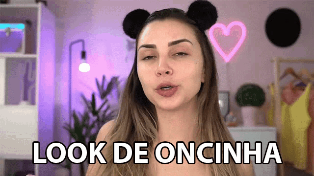 a woman wearing a headband with mickey mouse ears says " look de oncinha "