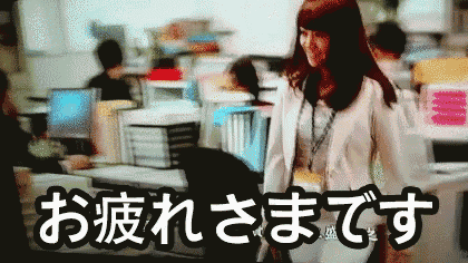 a woman is walking through an office with the words " お疲れさま です " in the upper right corner