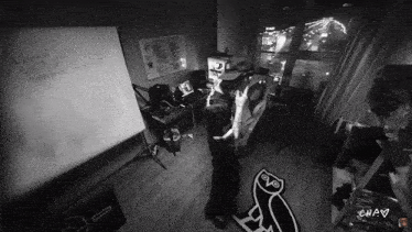 a black and white photo of a man standing in a room with a owl rug