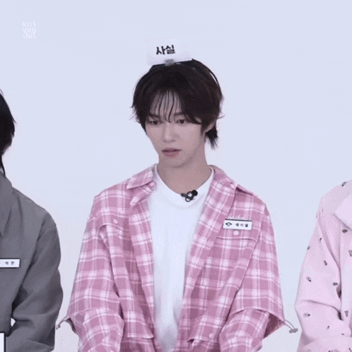 a boy in a pink plaid shirt has a name tag that says ' a '
