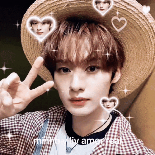 a young man wearing a straw hat and a plaid shirt is giving a peace sign