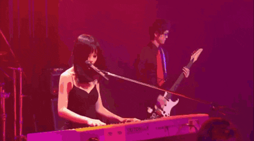 a woman is playing a keyboard that says triton