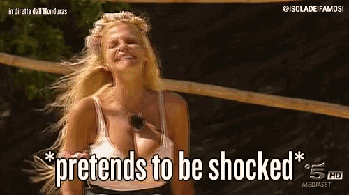 a woman says pretends to be shocked in front of a bamboo fence
