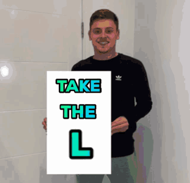 a man holding a sign that says " take the l "