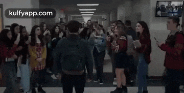 a group of people are standing in a hallway with a man standing in the middle .