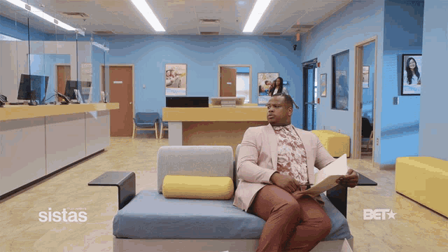 a man sits on a couch in a waiting room with bet written on the bottom