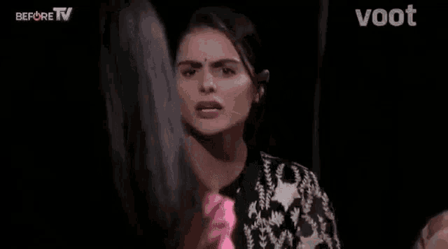 a woman in a black and white dress is standing in a dark room .