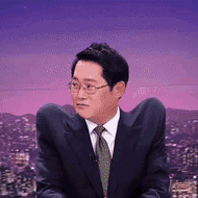 a man in a suit and tie with a purple sky in the background