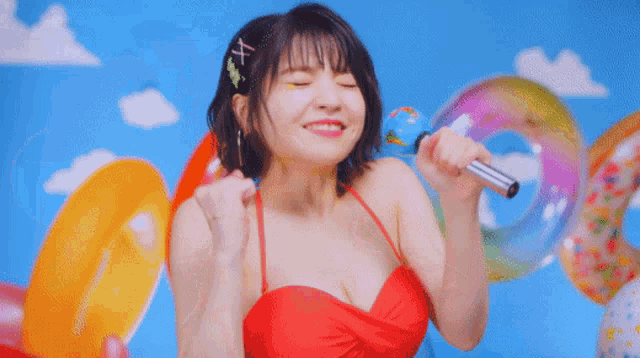 a woman is singing into a microphone while surrounded by balloons