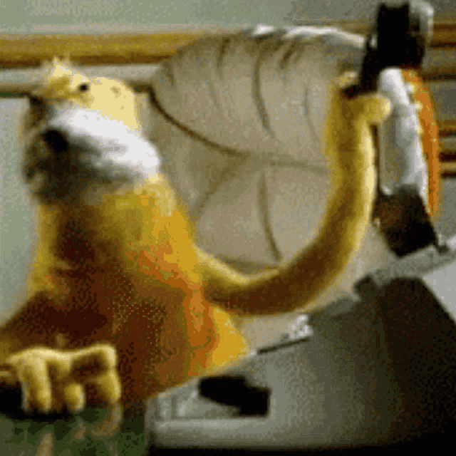 a stuffed animal with a long tail is sitting on a desk