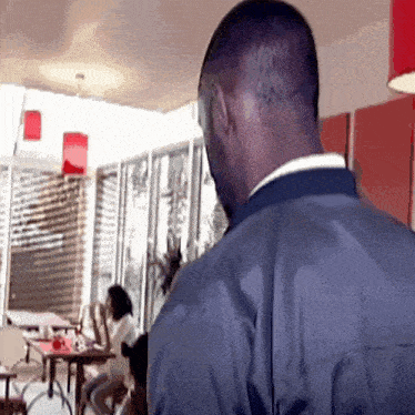 a man in a blue jacket stands in front of a restaurant