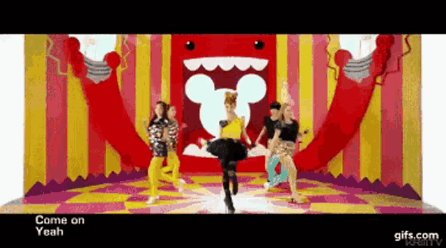 a group of girls are dancing in front of a mickey mouse cartoon
