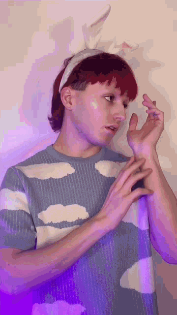 a man wearing bunny ears and a blue and white sweater