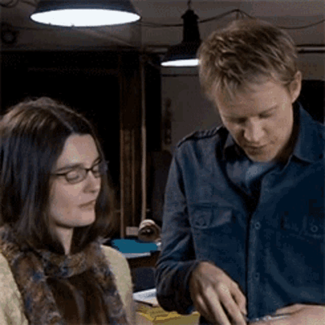 a man and a woman are standing next to each other in a room