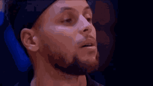 a close up of a man with a beard wearing a black hat and a headband .